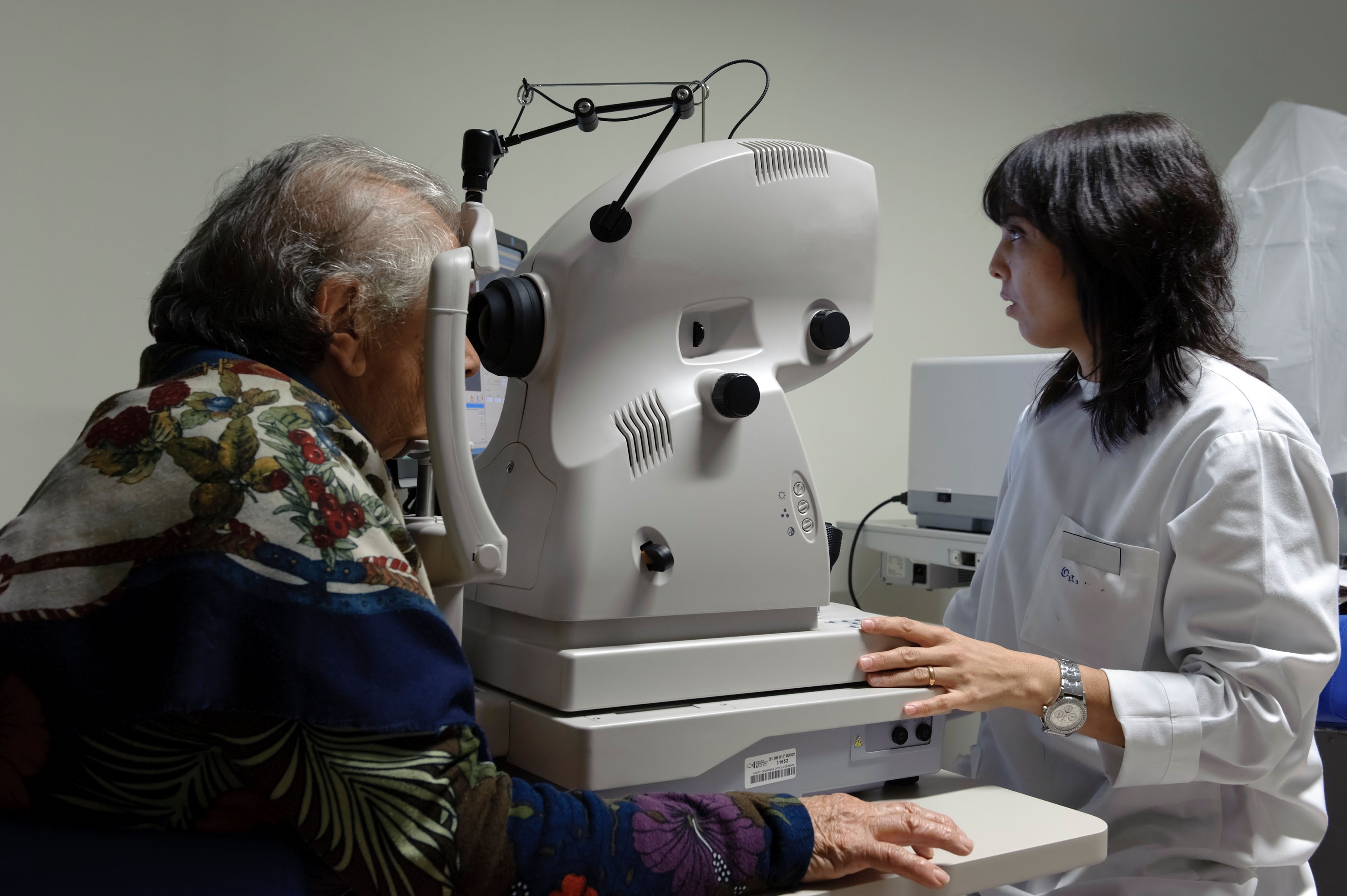 Augenärztin misst Augen von Patient mit OCT-Gerät
